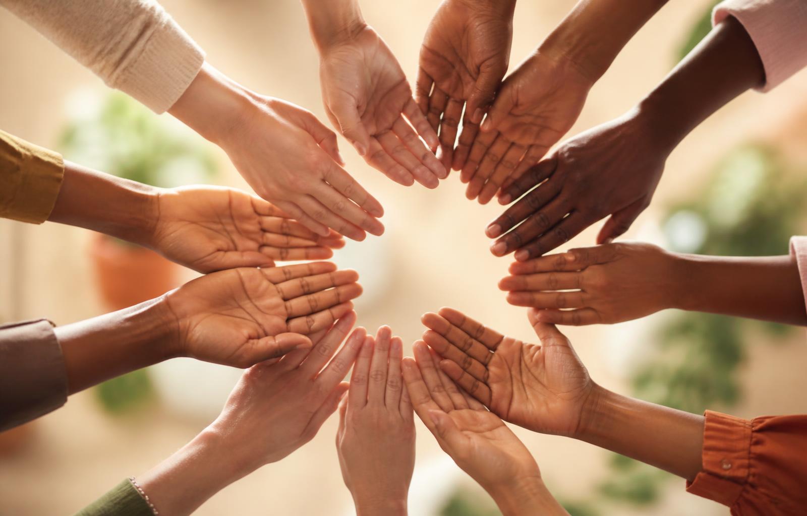 Diverse hands reaching together in unity